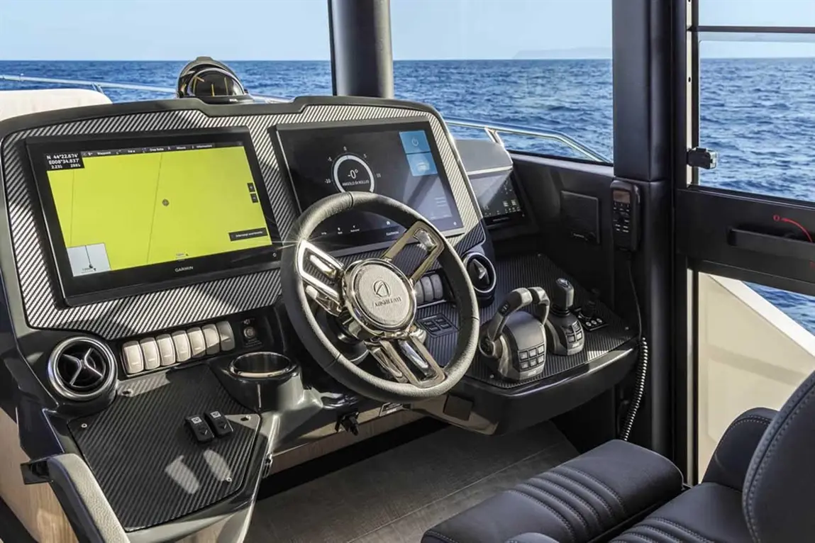 Luxury boat dashboard showcasing Garmin navigation screens, steering wheel, and controls with ocean view.